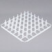 A white plastic grid with square compartments and spikes.
