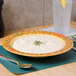 A Venetian melamine bowl filled with soup on a table with a spoon and a glass of water.