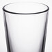A close up of a Libbey tall mixing glass with a black rim.