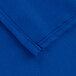 A close up of a folded edge on a royal blue poly/cotton table cover.