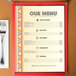 Menu insert with Southwest themed fiesta border design on a table with a fork and knife.