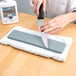 A person using a Victorinox sharpening stone to sharpen a knife on a table.