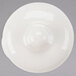 A white round lid with a small hole in the middle on a white surface.