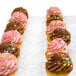 A row of InnoPak cupcakes with chocolate frosting and sprinkles in a clear container.