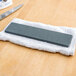 A Victorinox Coarse Sharpening Stone on a towel next to a knife.
