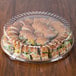 A Solut clear plastic catering tray lid on a table of sandwiches.
