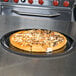 A pizza on a Solut black oven safe paperboard tray.