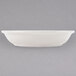 A white Homer Laughlin Empire coupe china soup bowl on a gray surface.