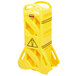 A yellow plastic Rubbermaid safety barrier with a warning sign.