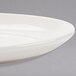 A close up of a Homer Laughlin ivory coupe oval china platter with a curved edge.