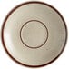 A white stoneware saucer with brown speckled design on the rim.