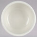A Tuxton eggshell white china bowl with a white rim.