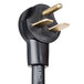 A close-up of a black power cord with gold electrical plugs.