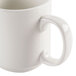 A CAC ivory china mug with a handle on a white surface.