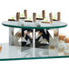 An Eastern Tabletop round acrylic display shelf with desserts on it in a bakery display.