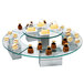 An Eastern Tabletop quarter circle acrylic buffet shelf with a display of cakes and desserts on a glass table.