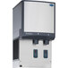 A grey rectangular Follett 25 Series air cooled ice and water dispenser with a white cover.