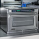 An Amana heavy duty stainless steel commercial steamer microwave oven on a counter.
