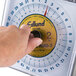 A person using an Edlund portion scale by turning a dial.