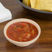 A bowl of GET Sandstone salsa and chips on a table.