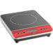 An Avantco black and red countertop induction range on a counter.