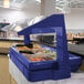 A navy blue Cambro buffet with food in it.