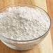 A bowl of ADM High Gluten Flour on a wood surface.