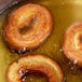 A pan filled with donuts frying in Zero Trans Fat Donut Fry Shortening.