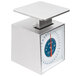 An Edlund stainless steel portion scale with a blue and red dial on a counter.