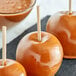 A group of caramel apples on Royal Paper eco-friendly wood skewers.