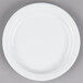 A Tuxton Colorado bright white narrow rim china plate on a gray surface.