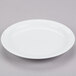 A Tuxton Colorado white plate with a narrow rim on a gray surface.