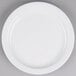 A Tuxton Colorado white china plate with a white rim on a gray surface.