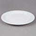 A Tuxton Colorado white china plate with a narrow rim on a gray surface.