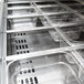 A Turbo Air 2 door stainless steel sandwich prep table with trays of food.