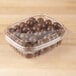 A Genpak plastic container filled with chocolate balls.