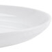A close up of a CAC Super Bright White porcelain salad bowl with rolled edges.