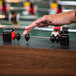 A person's hand touches the Atomic Gladiator Foosball table.