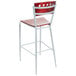 A mahogany finish bar stool with a white seat and red accents.