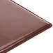 A brown Menu Solutions Hamilton chocolate menu board on a brown table.