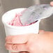 A person using a Zeroll TubMate ice cream spade to scoop ice cream into a cup.