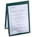 A Menu Solutions green sewn edge table tent with a menu card on a table.