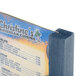 A Menu Solutions denim wood table tent with a blue and yellow design holding a menu on a table.