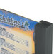 A black wood Menu Solutions table tent holding a menu on a table.