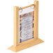 A Menu Solutions natural wood flip top table tent with a menu in a wooden frame.