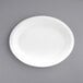 An EcoChoice Bagasse oval platter with a white rim on a gray surface.