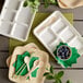 A white EcoChoice compostable bagasse tray with 6 compartments holding a spoon and blueberries.