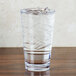 A GET Revo plastic stackable tumbler filled with ice water on a table.