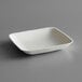 An EcoChoice Bagasse square appetizer plate on a gray surface.