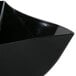 A close up of a Fineline black plastic bowl with a curved edge.